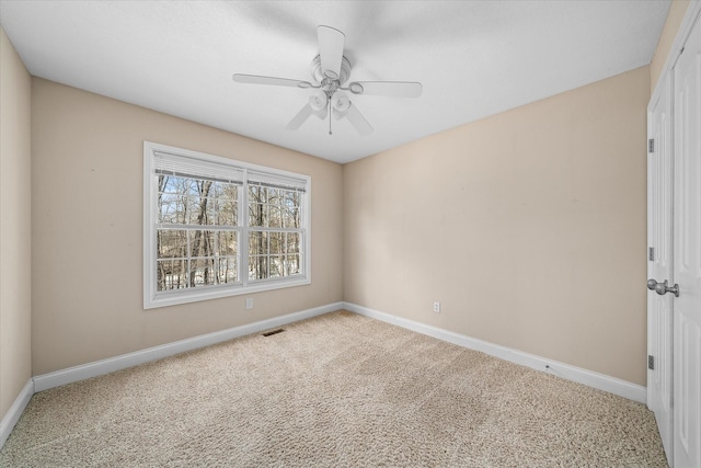 carpeted spare room featuring ceiling fan