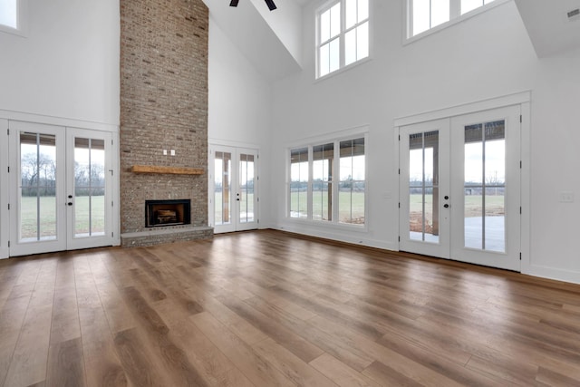 unfurnished living room with a towering ceiling, french doors, and a healthy amount of sunlight