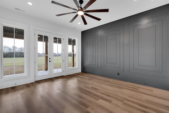 interior space with ceiling fan, french doors, plenty of natural light, and hardwood / wood-style flooring