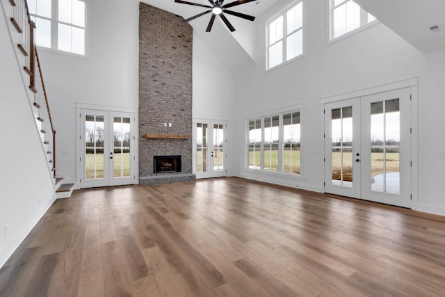 unfurnished living room featuring a towering ceiling and french doors