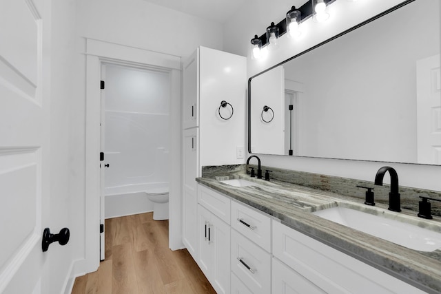 full bathroom with shower / bath combination, toilet, vanity, and hardwood / wood-style flooring