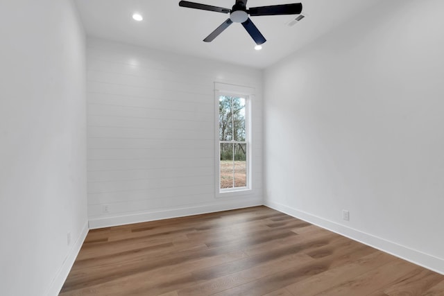 empty room with hardwood / wood-style floors and ceiling fan