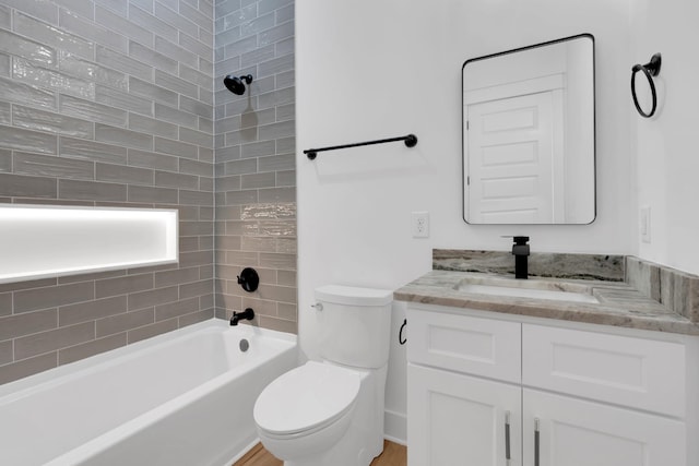 full bathroom featuring toilet, vanity, and tiled shower / bath