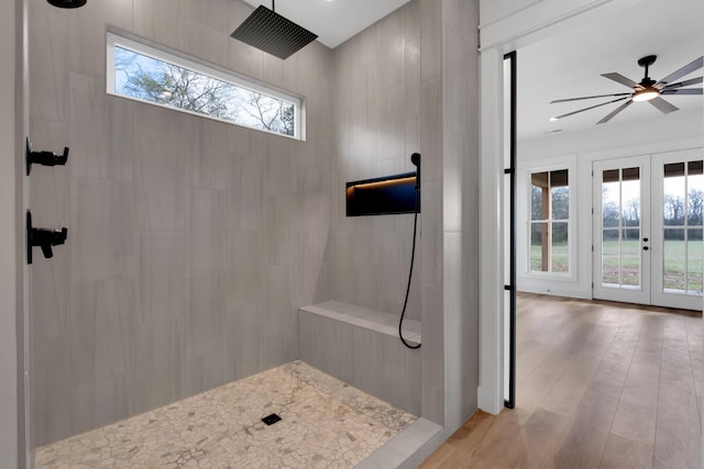 bathroom featuring a healthy amount of sunlight, french doors, and a tile shower