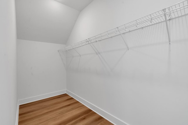 walk in closet featuring lofted ceiling and hardwood / wood-style flooring