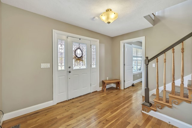 entrance foyer featuring a textured ceiling and light hardwood / wood-style floors