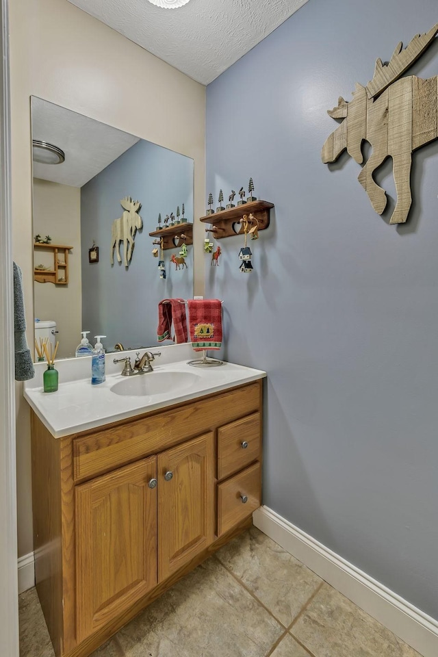 bathroom featuring a textured ceiling, tile patterned floors, and vanity