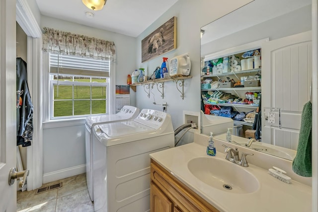 washroom with separate washer and dryer, sink, and light tile patterned floors