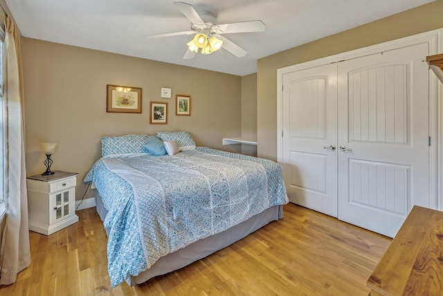 bedroom with ceiling fan, light hardwood / wood-style floors, and a closet