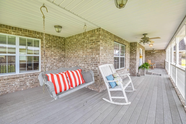 wooden deck featuring covered porch and ceiling fan