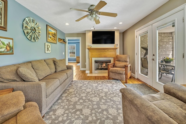 living room featuring ceiling fan, french doors, and light hardwood / wood-style flooring