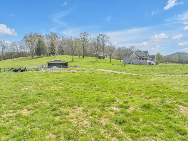 view of yard with a rural view and an outdoor structure