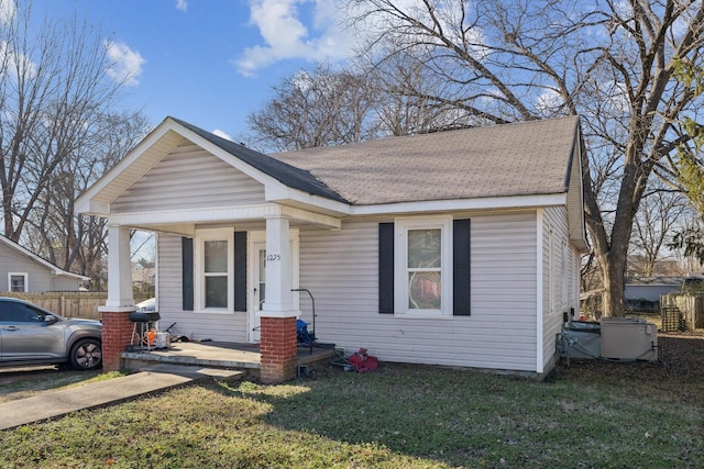 bungalow with a porch and a front lawn