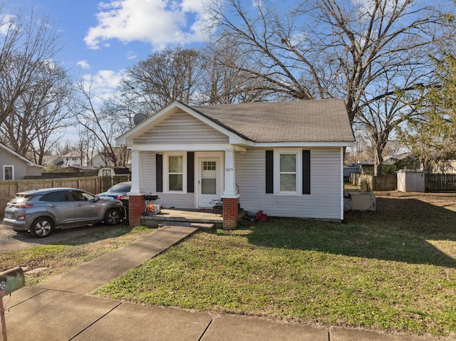 bungalow-style home featuring covered porch and a front lawn