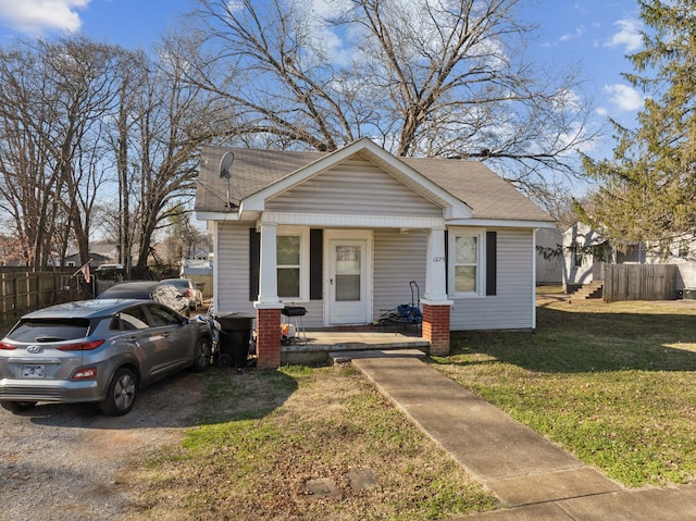 bungalow-style home featuring covered porch and a front yard