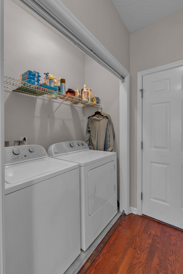 washroom featuring washer and dryer, a textured ceiling, and wood-type flooring