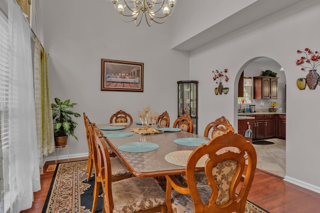 dining room featuring wood-type flooring and an inviting chandelier