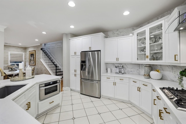 kitchen with white cabinets, appliances with stainless steel finishes, tasteful backsplash, and sink