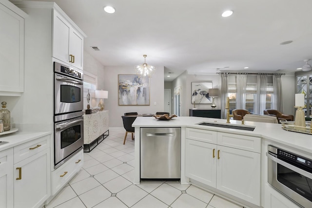 kitchen featuring a chandelier, hanging light fixtures, white cabinetry, appliances with stainless steel finishes, and sink