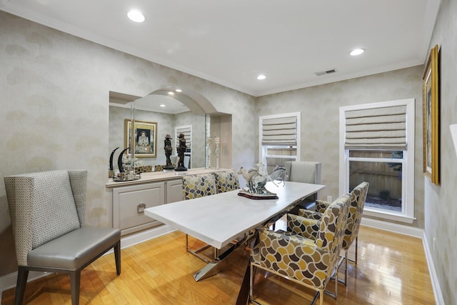 dining area featuring ornamental molding and light wood-type flooring