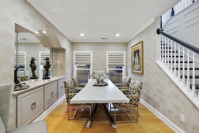 dining area featuring ornamental molding and light hardwood / wood-style flooring