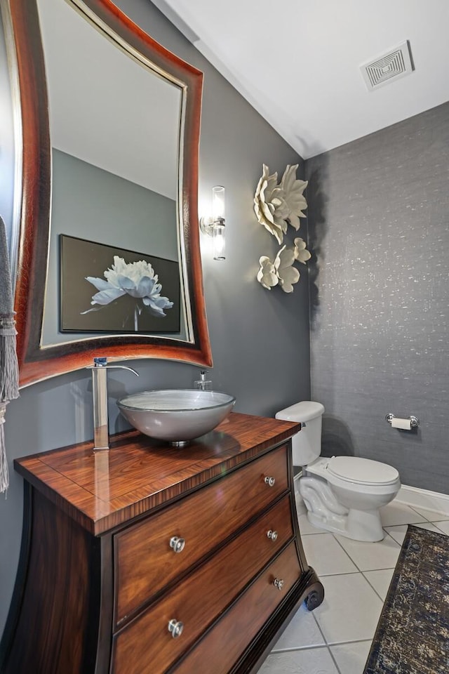 bathroom with tile patterned flooring, vanity, and toilet