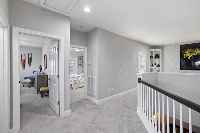 hallway featuring light colored carpet and plenty of natural light