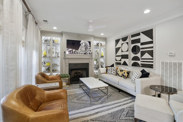 living room with ornamental molding and ceiling fan