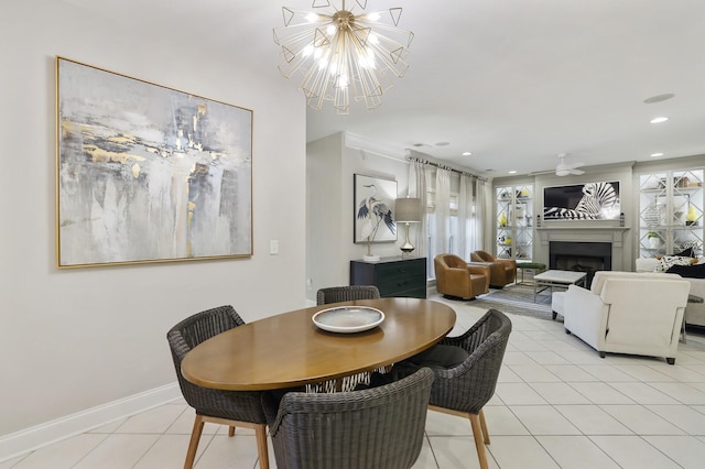 tiled dining space featuring ceiling fan with notable chandelier