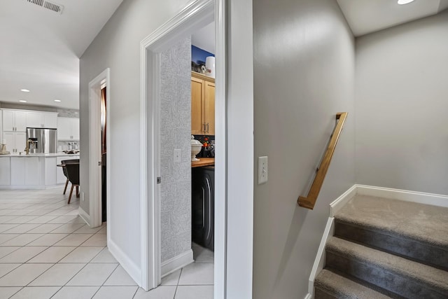 stairs with washer / clothes dryer and tile patterned flooring