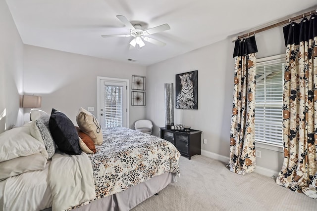 bedroom featuring ceiling fan, light carpet, and multiple windows