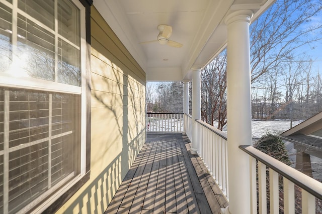 snow covered back of property with ceiling fan