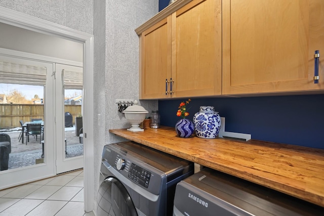 washroom with separate washer and dryer, cabinets, and light tile patterned floors