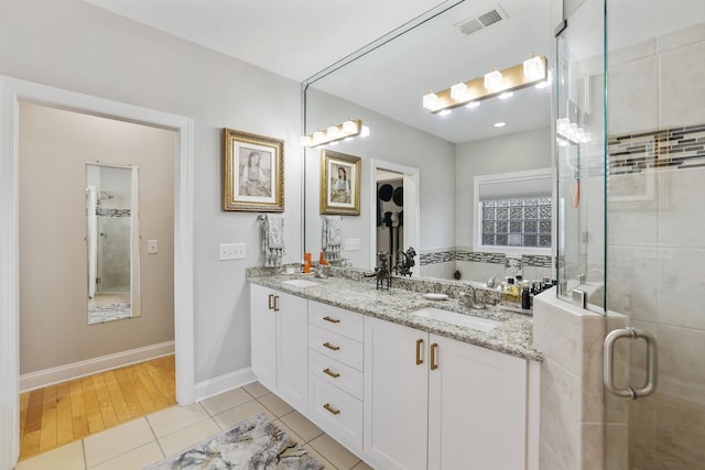 bathroom with tile patterned flooring, walk in shower, and vanity