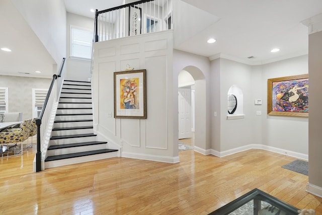 foyer with ornamental molding and hardwood / wood-style flooring