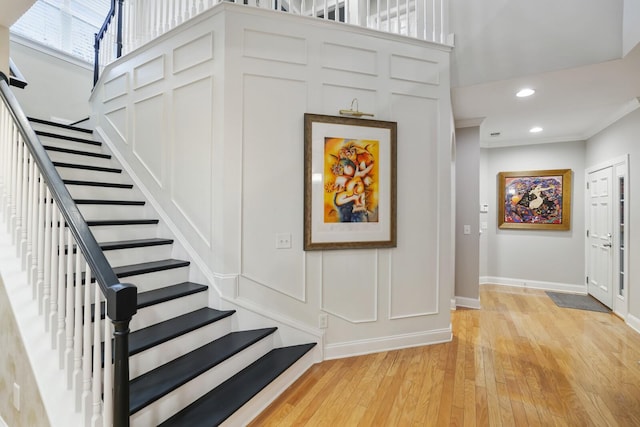 stairway featuring ornamental molding and wood-type flooring