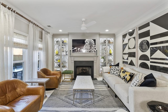 living room with ceiling fan and ornamental molding