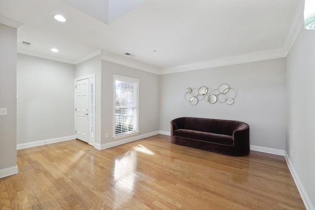 living area featuring crown molding and light wood-type flooring