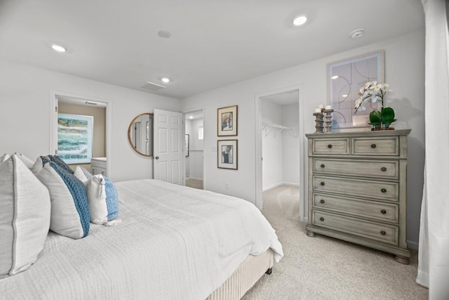 carpeted bedroom with a walk in closet and a closet