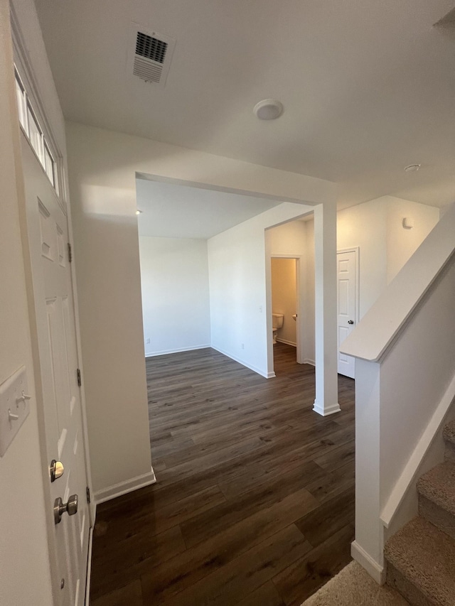 corridor with dark hardwood / wood-style flooring