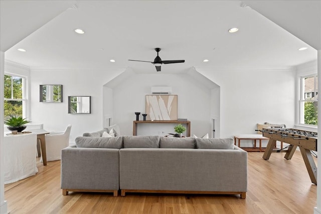 living room with ceiling fan, light wood-type flooring, ornamental molding, and a healthy amount of sunlight