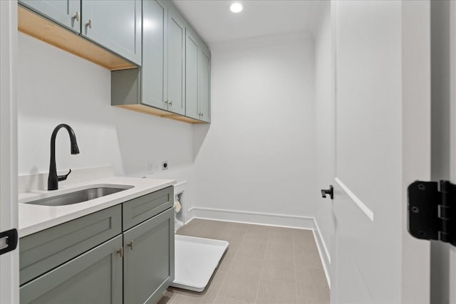 washroom with electric dryer hookup, cabinets, and sink