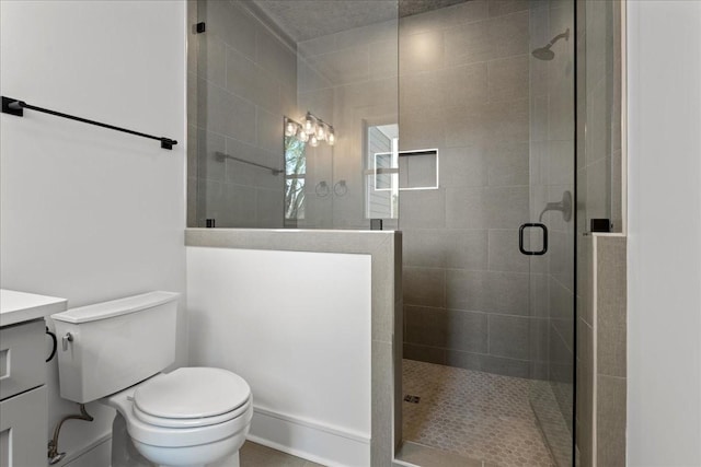 bathroom with toilet, vanity, and a shower with shower door