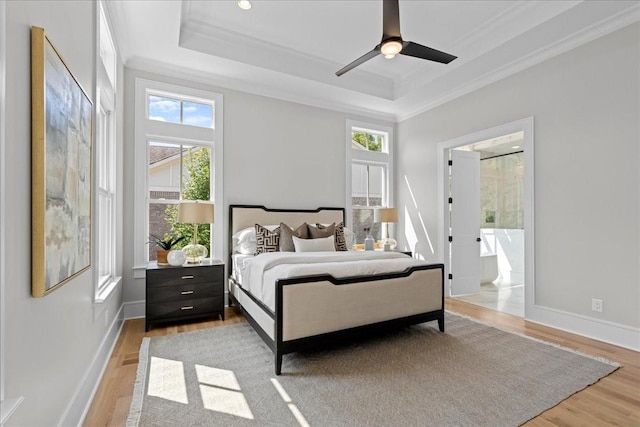 bedroom with multiple windows, ceiling fan, light hardwood / wood-style floors, and a raised ceiling