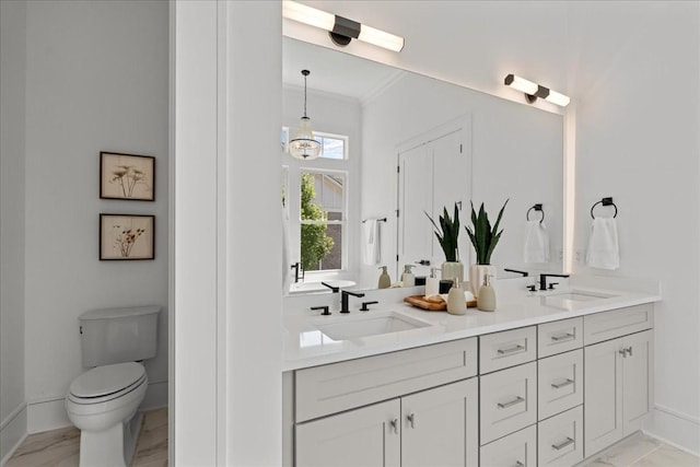 bathroom with toilet, vanity, and crown molding