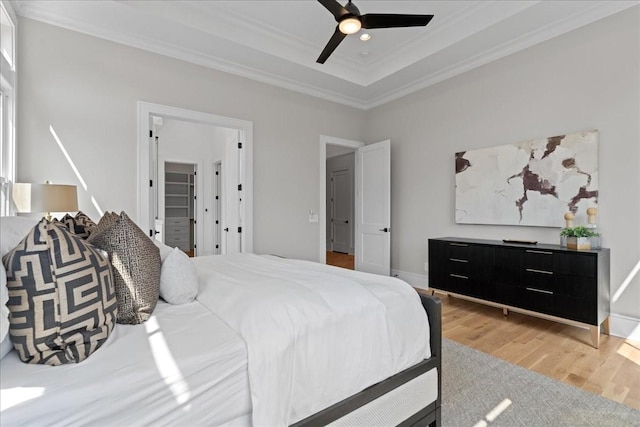 bedroom with ornamental molding, ceiling fan, and light hardwood / wood-style floors