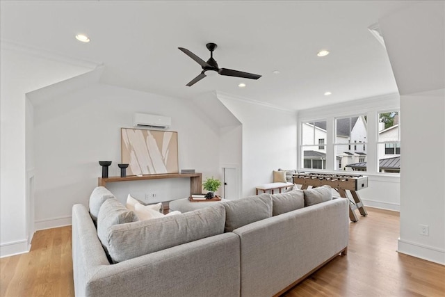 living room featuring an AC wall unit, light wood-type flooring, ceiling fan, and ornamental molding