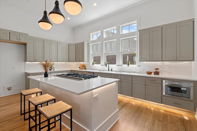 kitchen with sink, a breakfast bar area, a center island, and a wealth of natural light