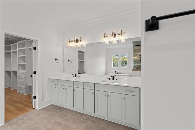 bathroom featuring tile patterned flooring, crown molding, and vanity