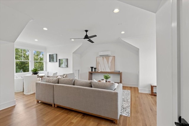 living room featuring a wall mounted AC, ceiling fan, and light hardwood / wood-style flooring